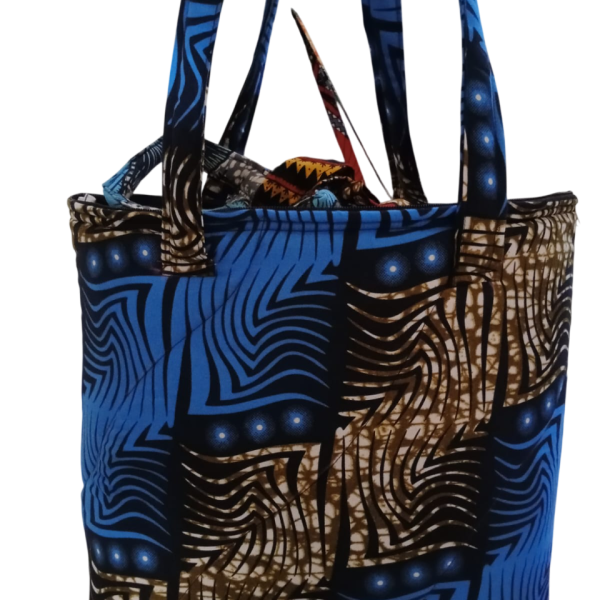 Upgrade your daily carry with our African Print Zip-Top Tote. Perfectly balancing functional design with high-impact aesthetics, this bag takes you from morning meetings to weekend brunch without missing a beat. Product Features: Secure Closure: Durable top zipper to keep your essentials safe. Spacious Design: Roomy interior for your laptop, makeup bag, and daily essentials. Sturdy Straps: Reinforced shoulder straps for comfortable all-day wear. Premium Fabric: 100% authentic African Wax Print (Ankara) with a structured lining.