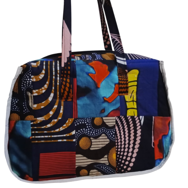Upgrade your daily carry with our African Print Zip-Top Tote. Perfectly balancing functional design with high-impact aesthetics, this bag takes you from morning meetings to weekend brunch without missing a beat. Product Features: Secure Closure: Durable top zipper to keep your essentials safe. Spacious Design: Roomy interior for your laptop, makeup bag, and daily essentials. Sturdy Straps: Reinforced shoulder straps for comfortable all-day wear. Premium Fabric: 100% authentic African Wax Print (Ankara) with a structured lining.